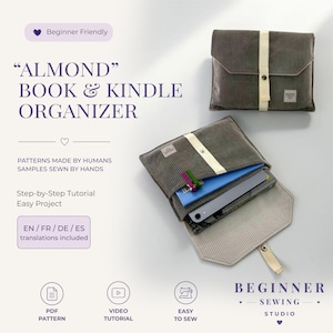 May include: A grey corduroy book and Kindle organiser with a cream-coloured strap and snap closure. One organiser is closed, while the other is open, revealing a blue notebook, a tablet, and two pens inside. Text includes "ALMOND BOOK & KINDLE ORGANISER".