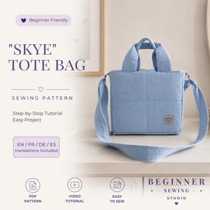 Pode incluir: Uma bolsa tote quadrada azul-clara com duas alças superiores e uma alça de ombro longa. A bolsa apresenta um padrão de grade acolchoado e uma pequena etiqueta retangular na frente. O texto na imagem inclui "SKYE" TOTE BAG, Beginner Friendly, SEWING PATTERN, Step-by-Step Tutorial, Easy Project, EN/FR/DE/ES translations included, PDF PATTERN, VIDEO TUTORIAL, EASY TO SEW e BEGINNER SEWING STUDIO.