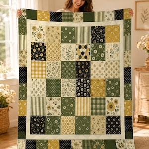 Puede incluir: Una colcha de patchwork rectangular que presenta una variedad de cuadrados de tela en tonos verde oliva, amarillo mostaza, negro y blanco. El diseño incluye estampados florales, cuadros vichy, rayas, lunares y motivos geométricos.