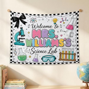 May include: A rectangular wall tapestry featuring a white background with a black and white checkered border. The text reads Welcome to MRS. WILLIAMS'S Science Lab. Illustrations include a black bow, microscope, beakers, test tubes, and goggles.