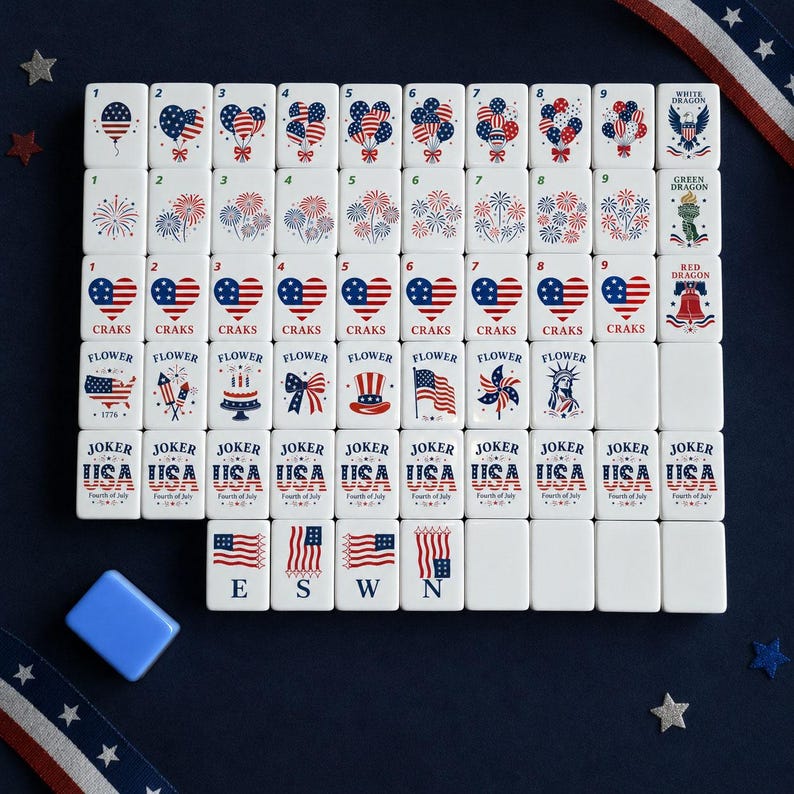 May include: A set of white rectangular mahjong tiles featuring red, white, and blue patriotic graphics including balloons, fireworks, hearts, the Statue of Liberty, and American flags. Each tile displays specific numbers, text, or symbols.