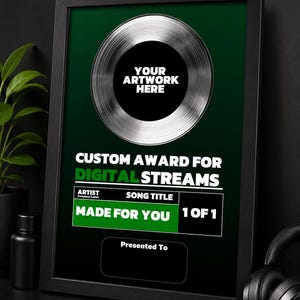 Può includere: Premio personalizzato incorniciato per streaming digitali. Il premio presenta un design a disco argentato con il testo "YOUR ARTWORK HERE" al centro. Il testo "CUSTOM AWARD FOR DIGITAL STREAMS" è visualizzato sopra le informazioni sull'artista e sul titolo della canzone. È visibile anche il testo "MADE FOR YOU".
