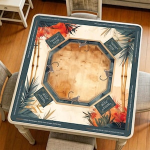 May include: Square wooden game table with a light wood centre and a dark teal border. The border features tropical floral and bamboo designs, with text that reads "JOKER MAY NEVER BE USED IN SINGLES OR PAIRS." The table has a unique octagonal centre with monkey illustrations.