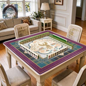 Oriental scenic game mat shown in use with mahjong tiles, highlighting the spacious square playing area, smooth cushioned surface, and refined artwork featuring a golden phoenix, koi fish, lotus details, stylized clouds, floral branches, and elegant framed borders in a rich purple, blue-green, gold, blush, and ivory palette.
