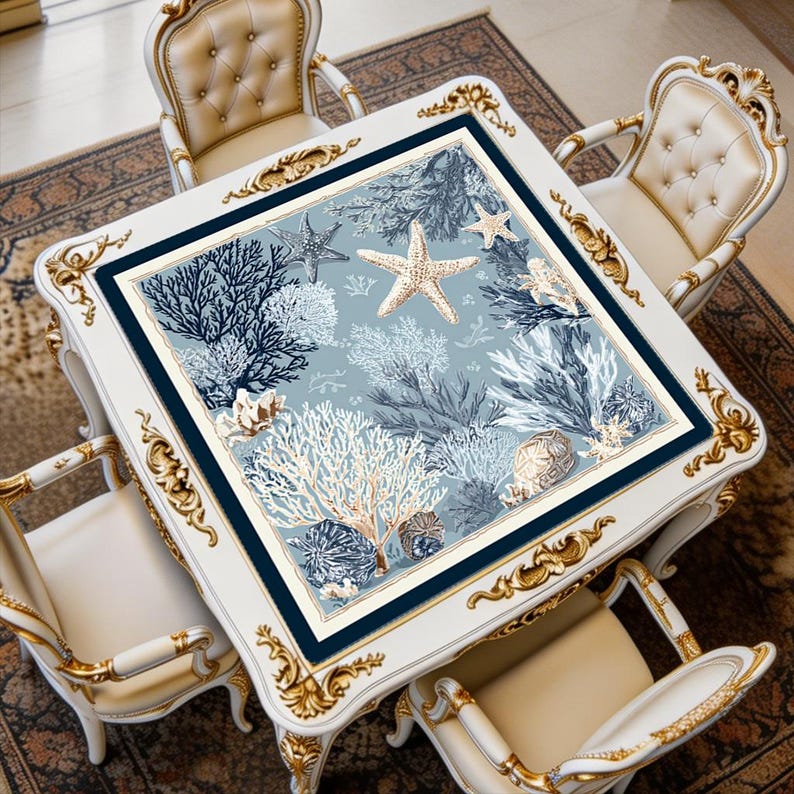Blue coral mahjong mat displayed on a square table, featuring starfish, shell, and ocean coral artwork in soft coastal tones.