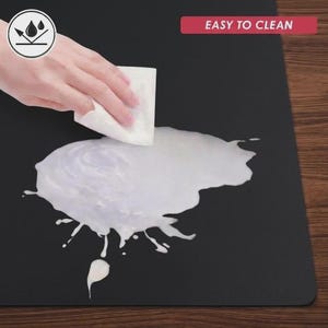 Easy-clean waterproof material demonstration showing liquid being wiped from the mat surface, emphasizing simple maintenance and practical everyday use.