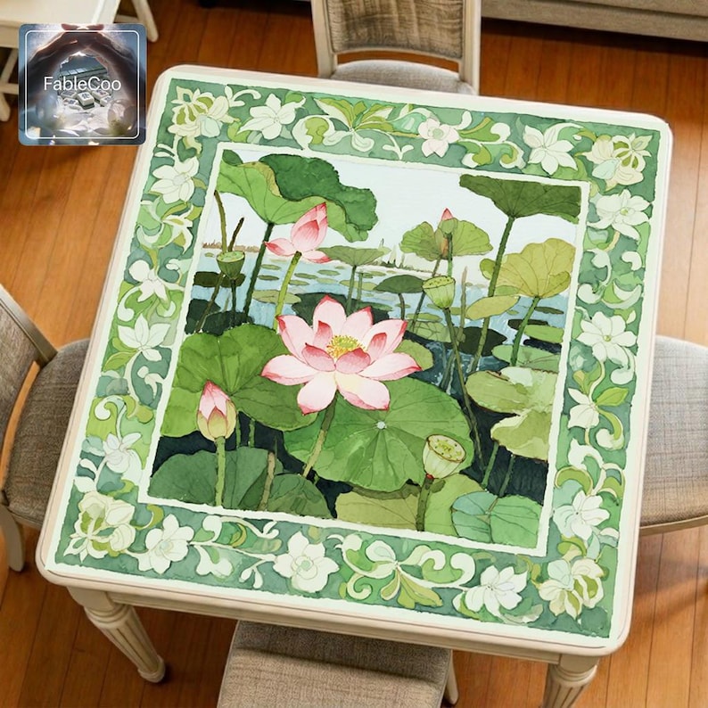 Pink lotus pond mahjong mat displayed on a square home table, featuring an original watercolor-inspired design with blooming pink lotus flowers, layered green lotus leaves, lotus pods, soft water reflections, and an elegant floral vine border in fresh green tones.