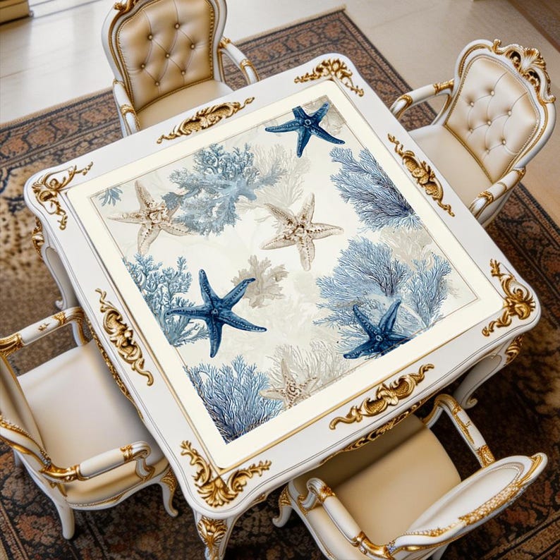 White ocean coral mahjong mat displayed on a square table, featuring blue starfish and coral artwork in a soft coastal color palette.