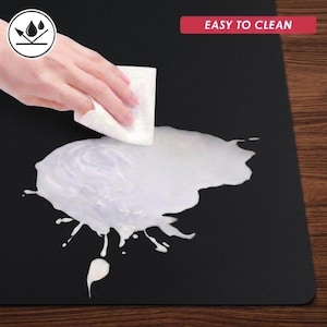 Exploded layered structure image showing the soft fabric top layer, cushioned middle layer, and non-slip rubber foam backing for comfort, grip, and table protection.