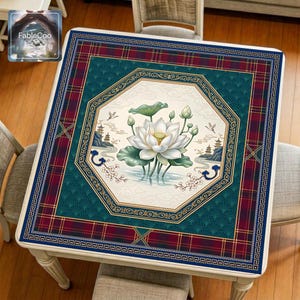 Asian-style mahjong mat displayed on a square home table, featuring an original oriental-inspired lotus scene with blooming white lotus flowers, lotus leaves, soft cloud motifs, distant pavilions, flying birds, and elegant geometric borders in navy blue, deep green, burgundy red, gold, ivory, and blush pink tones.