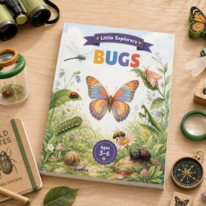May include: A children's book titled Little Explorers BUGS with a butterfly illustration, surrounded by a green magnifying glass, a wooden compass, a spiral-bound Field Notes notebook, a bug jar with a ladybug, binoculars, and wooden insect toys.