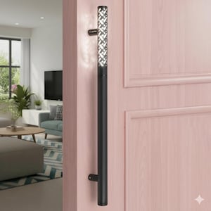May include: A black door pull handle with a patterned top section. The handle is mounted on a pink door. The top section has a repeating geometric design with cutouts. The handle is cylindrical and has a modern design.