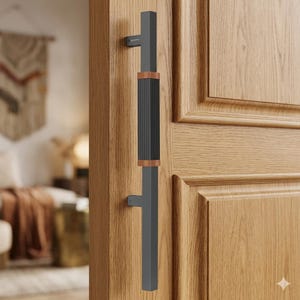 May include: A modern door handle with a dark gray finish, accented by a black ribbed center section and copper-toned trim. The handle is mounted on a light brown wooden door, showcasing a contemporary design.