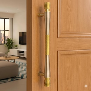 May include: A vertical door pull handle with a gold and silver finish. The handle has a ribbed gold center section and is mounted on a light brown wooden door. The handle is a modern design.