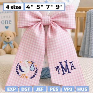 Puede incluir: Un lazo rosa y blanco a cuadros con detalles bordados. El lazo presenta una cigüeña que lleva un bebé en un bulto azul y las iniciales TMA. Tamaños disponibles: 10 cm, 13 cm, 18 cm y 23 cm.