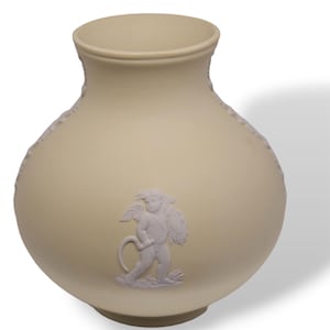 May include: Cream-coloured ceramic vase with a rounded body and a flared rim. The vase features a white relief of a cherub carrying a bundle. The vase has a classic, elegant design, suitable for decorative purposes.