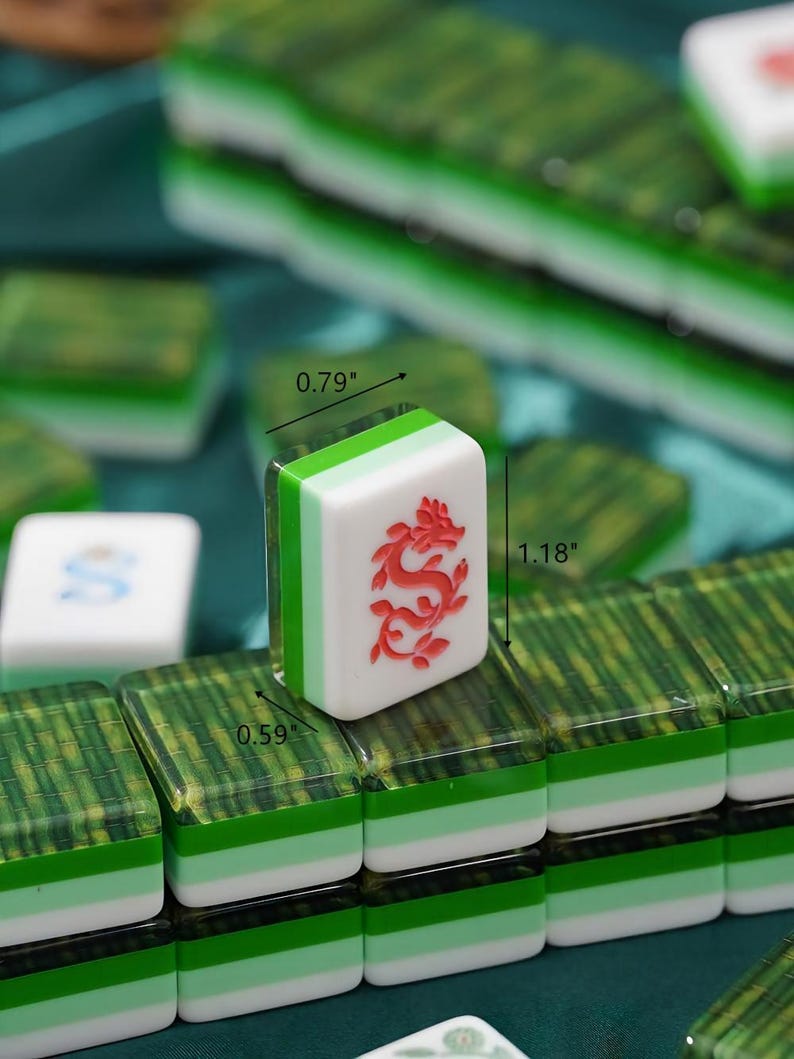 May include: A set of Mahjong tiles featuring a white face with a red dragon engraving. The tiles have a layered design with a green and white base and a translucent green top. Dimensions are clearly marked as 0.79 inches wide, 1.18 inches tall, and 0.59 inches deep.