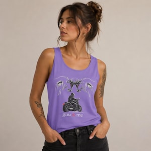 Puede incluir: Una camiseta de tirantes de color morado claro con un estampado gráfico de una persona montando una motocicleta. Sobre la moto hay dos cabezas de caballo blancas estilizadas frente a frente. El texto "gnu & me" aparece en blanco y rojo.