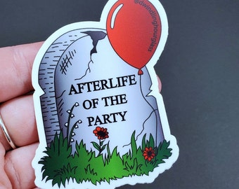 May include: A sticker depicting a grey tombstone with the text "AFTERLIFE OF THE PARTY". A red balloon is attached to the tombstone. Green grass and red flowers are at the base of the tombstone.