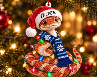 Adorno acrílico personalizado de serpiente de maíz con nombre personalizado, gorro de Papá Noel, bufanda azul y luces.