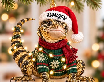 Adorno acrílico personalizado de lagarto monitor con nombre personalizado, gorro de Papá Noel, suéter, bufanda y luces.