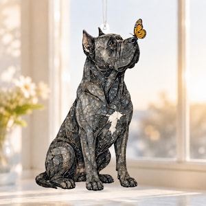 Könnte beinhalten: Ein hängendes Ornament, das einen dunkelgrauen Cane Corso Hund mit einem weißen Brustfleck und einem mosaikartigen Muster aus Linien und Punkten zeigt. Ein orange-schwarzer Monarchfalter sitzt auf der Nase des Hundes.