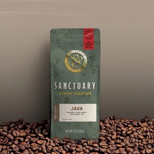May include: A green coffee bag with the text "SANCTUARY COFFEE ROASTING" and "JAVA" printed on it. The bag is surrounded by coffee beans. The bag's net weight is 12 oz (340 g).