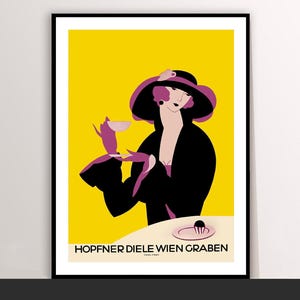 May include: A framed art print featuring a stylized illustration of a woman in a black coat and hat, holding a cup. The background is yellow, with the text "HOPFNER DIELE WIEN GRABEN" at the bottom. The woman is depicted in shades of black, purple, and pink.