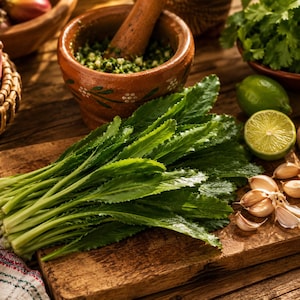 May include: Fresh green culantro leaves on a wooden cutting board, alongside garlic cloves, a lime, and a bowl of cilantro. A mortar and pestle with green herbs is in the background, suggesting culinary preparation.