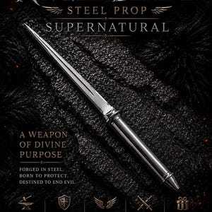 Puede incluir: Una hoja de utilería de acero de color plateado con punta afilada, un canal central y un mango cilíndrico. El texto dice: ANGEL BLADE, STEEL PROP, SUPERNATURAL, A WEAPON OF DIVINE PURPOSE, FORGED IN STEEL. BORN TO PROTECT. DESTINED TO END EVIL.