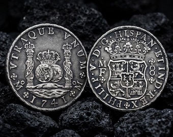 May include: Two silver-toned coins featuring intricate relief designs. The left coin displays two globes under a crown between two pillars with the text VTRAQUE VNUM 1741. The right coin shows a central shield with a crown and the text PHILIPP V D G HISPAN ET IND REX.