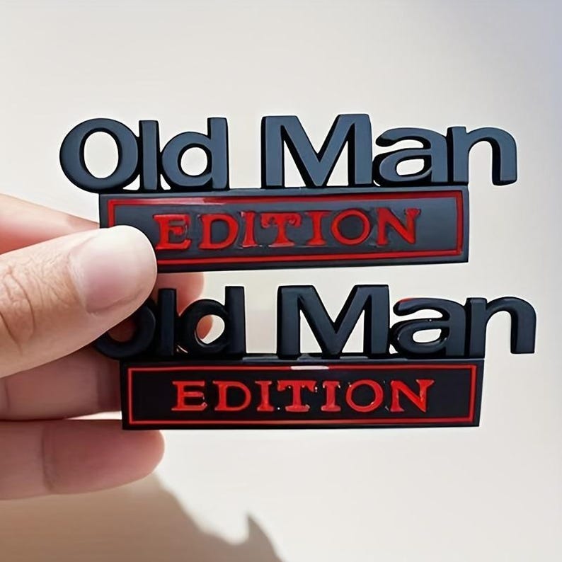 Pu&ograve; includere: Due emblemi neri e rossi "Old Man Edition". Il testo "Old Man" &egrave; in grassetto, con lettere a blocchi sopra la parola "Edition". La parola "Edition" &egrave; in lettere rosse.
