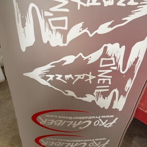 May include: A light brown surface featuring large white graphic text that reads O'NEIL KRENK in a stylized font. Below this, there are three stacked red oval outlines containing the white text PRO CALIBER and the website www.ProCaliberBend.com.