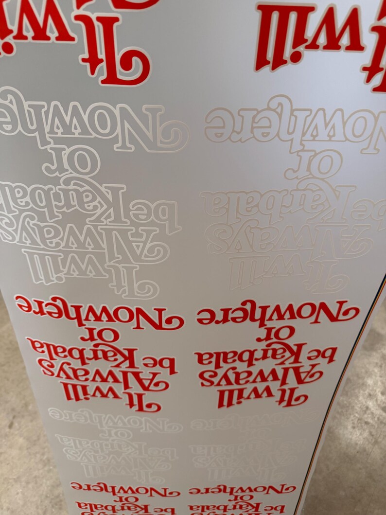 May include: A sheet of adhesive decals featuring the repeating text It will Always be Karbala or Nowhere in both bold red and subtle white lettering. The typography is stylized with a decorative serif font, arranged in multiple rows on a white background.