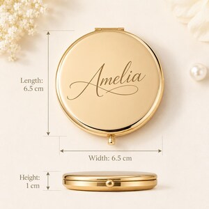 Pu&ograve; includere: Uno specchietto da borsa rotondo color oro con il nome Amelia inciso in corsivo sul coperchio. Lo specchio misura 6,5 cm di lunghezza, 6,5 cm di larghezza e 1 cm di altezza, come indicato dalle etichette di misurazione visibili.