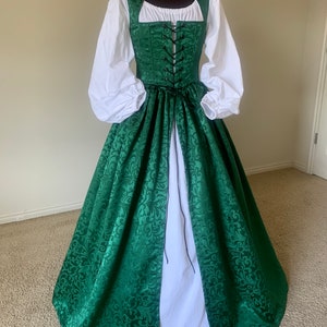 Puede incluir: Un vestido verde y blanco con un corpi&ntilde;o con cordones y una falda completa. El vestido tiene un estampado floral y est&aacute; hecho de una tela suave y fluida.