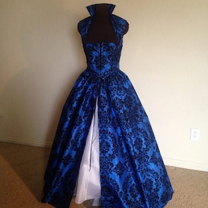 May include: A blue and black brocade ball gown with a black velvet bodice and a white petticoat.