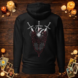 May include: A black hooded sweatshirt featuring a graphic on the back of an anatomical heart pierced by three silver swords. Red liquid drips from the heart, transitioning into a binary code pattern of ones and zeros in white text.