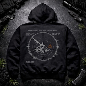 Può includere: Una felpa con cappuccio nera con una grafica bianca sul retro. Il design mostra un'interfaccia circolare in stile radar con la sagoma di una montagna, un triangolo di avvertimento arancione e il testo ANOMALY_DETECTED, REALITY_GLITCH, STATUS: CRITICAL.