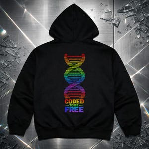Puede incluir: Sudadera con capucha negra con un diseño de hélice de ADN arcoíris. El diseño está compuesto por código binario y las palabras "CODED TO BE FREE" en degradado arcoíris. La sudadera tiene capucha con cordón y bolsillo de canguro.