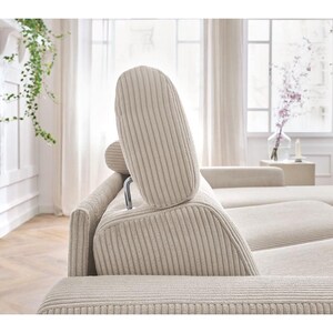 May include: Beige corduroy sectional sofa with adjustable headrests. The sofa has a modern design with a neutral colour palette, suitable for a living room. The headrests are supported by a silver metal frame.