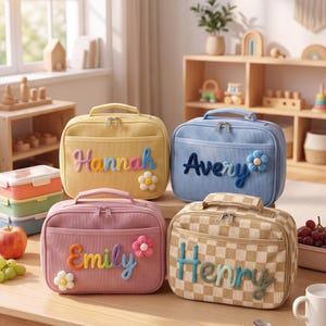 May include: Four rectangular lunch bags with top handles and zippered closures. The bags are yellow, blue, pink, and a tan checkerboard pattern. Each bag features a personalized name in raised, colorful yarn lettering and a small flower accent.