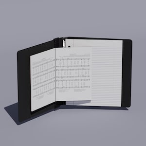 Può includere: Una cartella per spartiti nera con un sistema di visualizzazione interno a più pagine. La cartella è aperta e mostra una pagina di spartito con notazione musicale e testi, accanto a una pagina a righe vuota per appunti, fissata da un meccanismo centrale.