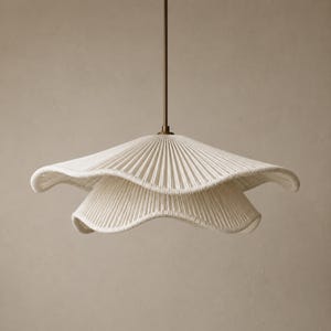 May include: A two-tiered pendant light fixture featuring a cream-colored, pleated fabric shade with a wavy, scalloped edge. The shade is suspended from a thin, straight, dark metallic rod that connects to the center of the fixture.