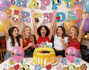 Może przedstawiać: Scena przyjęcia urodzinowego z udekorowanym tortem, babeczkami i balonami. Tort ma żółtą polewę i topper "Happy Birthday". Baner głosi "Happy Birthday" z postaciami z kreskówek. Kilka osób świętuje.