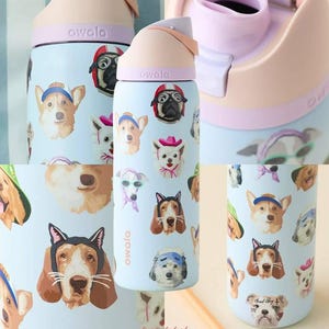 Pu&ograve; includere: Una borraccia Owala azzurra con un motivo ripetuto di varie razze canine che indossano accessori come cappelli, fasce e occhiali da sole. Il tappo, di colore rosa chiaro e lavanda, &egrave; dotato di un beccuccio integrato e di una maniglia.