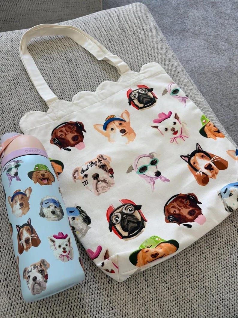 Pu&ograve; includere: Una borsa tote in tela bianca con bordo superiore smerlato e una borraccia azzurra, entrambe caratterizzate da un motivo ripetuto di varie razze canine che indossano cappelli, occhiali e cuffie colorati, con il testo Good Boy 777 su un cane.