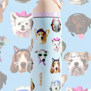 Pu&ograve; includere: Una borraccia Owala azzurra con un motivo ripetuto di varie razze canine che indossano accessori come cappelli, foulard e occhiali. La bottiglia ha un tappo color pesca e il nome del marchio Owala stampato in bianco sul lato.