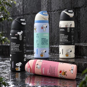 Può includere: Quattro borracce Owala in nero, azzurro, crema e rosa, ciascuna con grafiche di Snoopy e il testo, Hi there. I'm leak proof. I'm insulated. And I have a built-in straw. Ogni borraccia ha una capacità di 945 ml e un coperchio con chiusura.