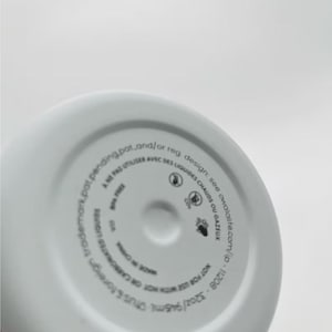 May include: White insulated water bottle base with printed text. The text includes the bottle's capacity of 32oz/946ml, and warnings about use with hot or carbonated liquids. The bottle is made in China.